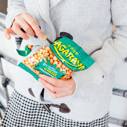 Person holding a package of Nagaraya Garlic Cracker Nuts with a blurred background